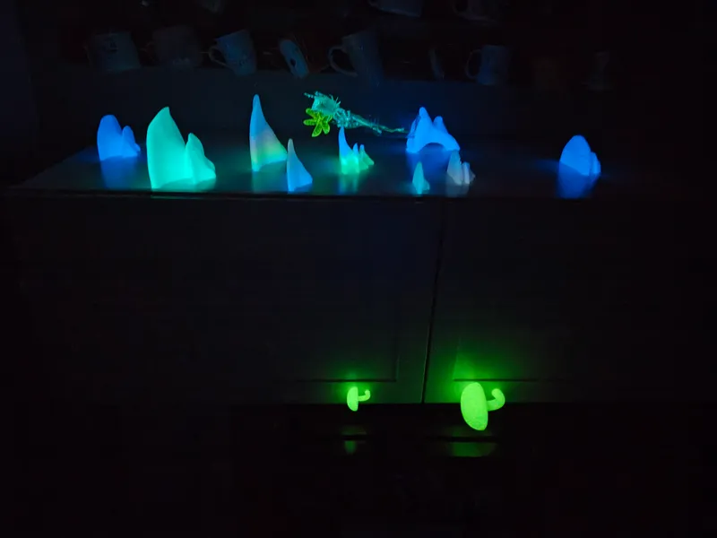 A cluster of glowing blue and green mushrooms across a dresser top, with two green mushroom-shaped drawer pulls lit below